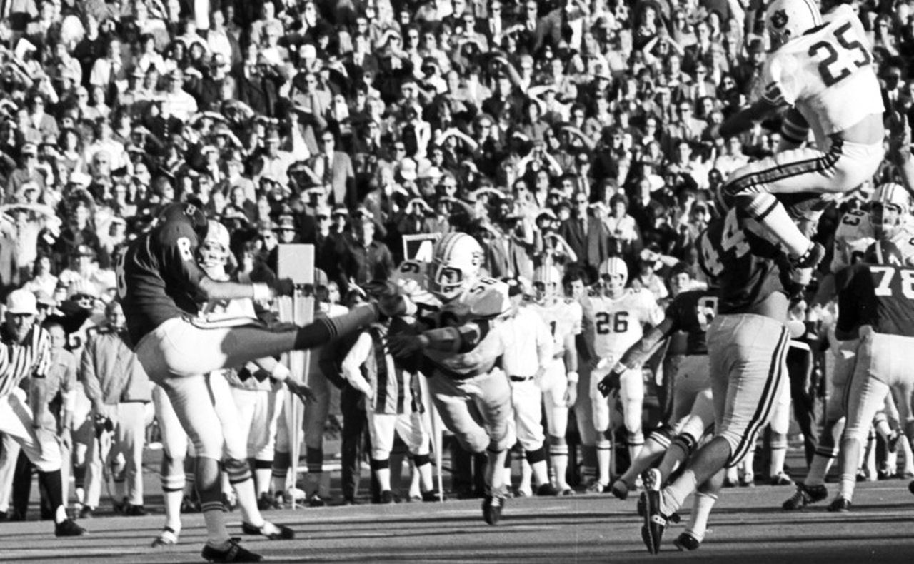 Auburn play Bill Newton (#56) blocking a punt by Alabama player Greg Gantt (#8) during the 1972 Iron Bowl game at Legion Field in Birmingham, Alabama.