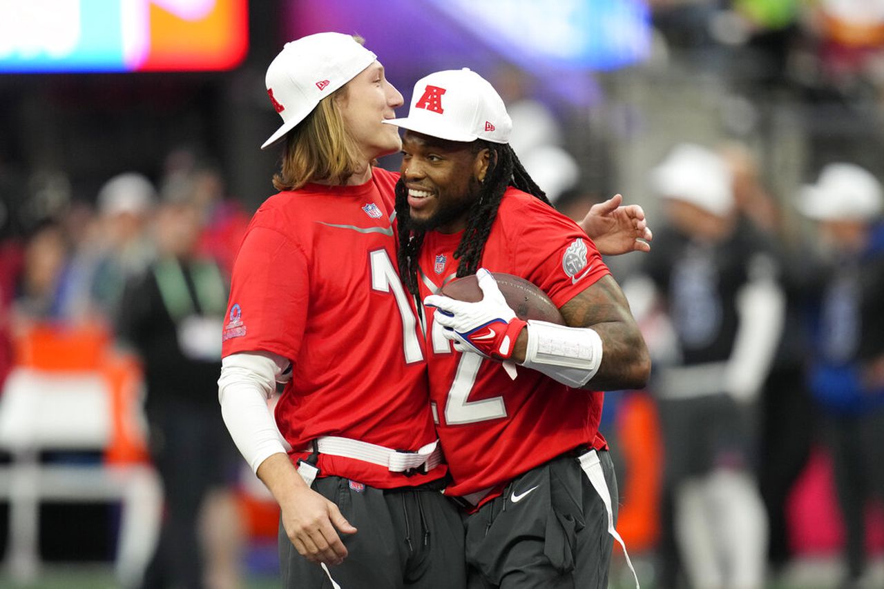 Tennessee Titans running back Derrick Henry (22) celebrates with Jacksonville Jaguars quarterback Trevor Lawrence