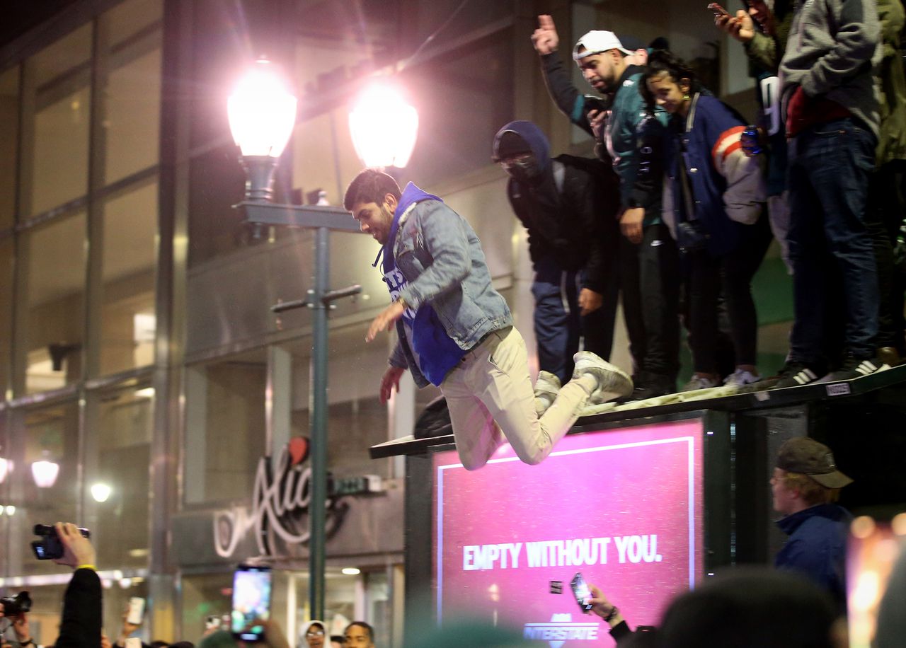 Philadelphia Eagles fans flip car, climb street lights, jump from bus shelter as Chiefs win Super Bowl