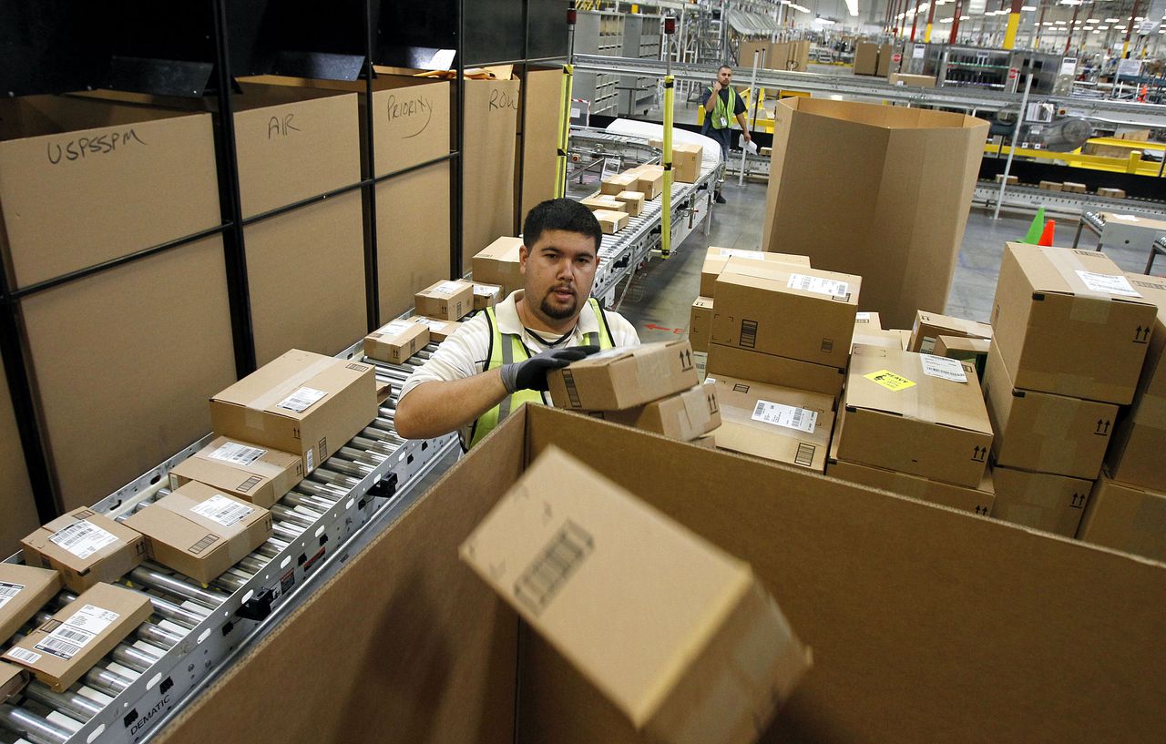 Ricardo Sandoval places packages in the right shipping boxes at an Amazon.com fulfillment center, in Phoenix, in a 2010 file photo