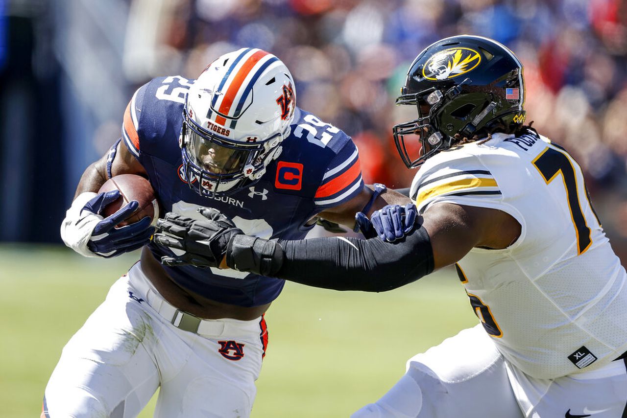 Auburn defensive end Derick Hall runs with the football after intercepting a pass