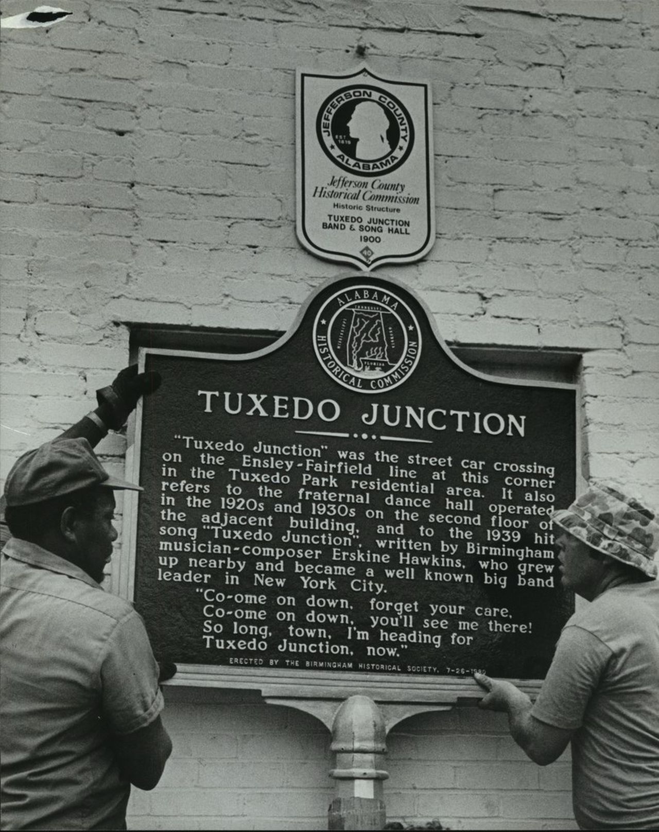 Workmen unveil a marker commemorating Erskine Hawkins and Tuxedo Junction's musical heritage.