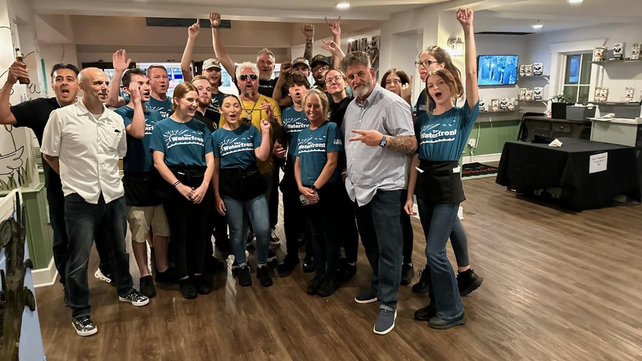 Guy Fieri, center in yellow shirt, raises a cheer with Pete Blohme and the staff of The Waterfront in Daphne.