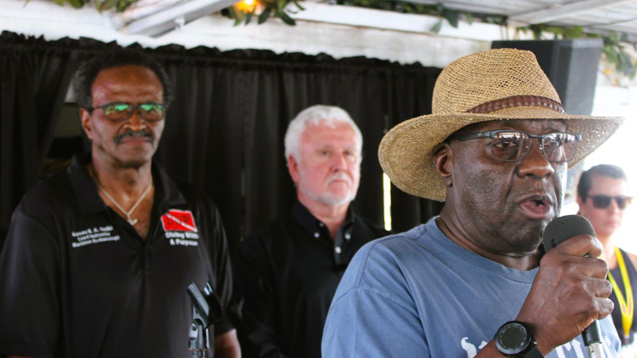 Darron Patterson, right, past president of the Clotilda Descendants Association, speaks about the importance of the Clotilda survivors' legacy during a boat trip to the slave ship's wreck site on July 7, 2023. Behind him are Kamau Sadiki of Diving With a Purpose, left, and marine archaeologist James Delgado.