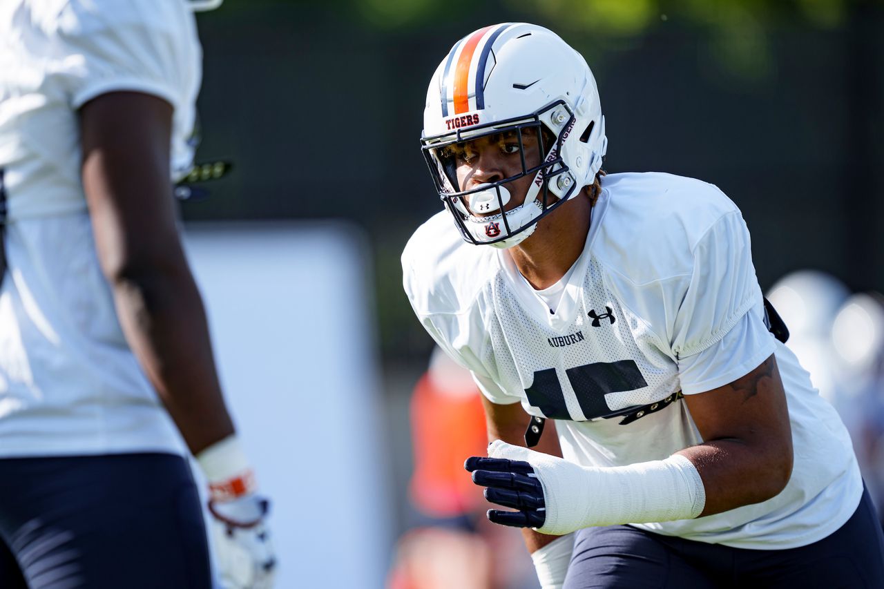 What does Keldric Faulk's move to defensive end mean for Auburn's defensive line?
