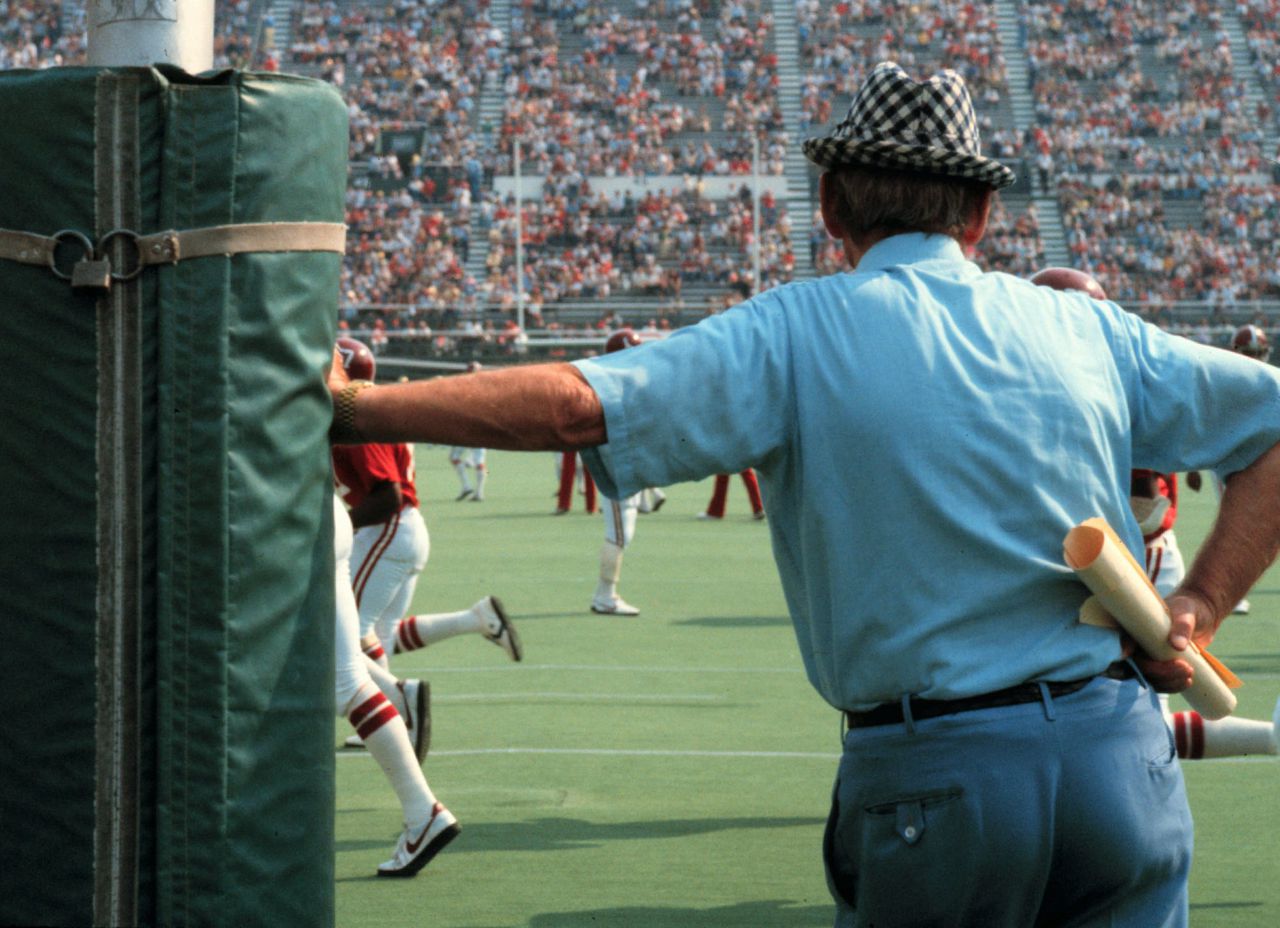 Alabama football traditions: Coach Bryant leaning against the goalposts