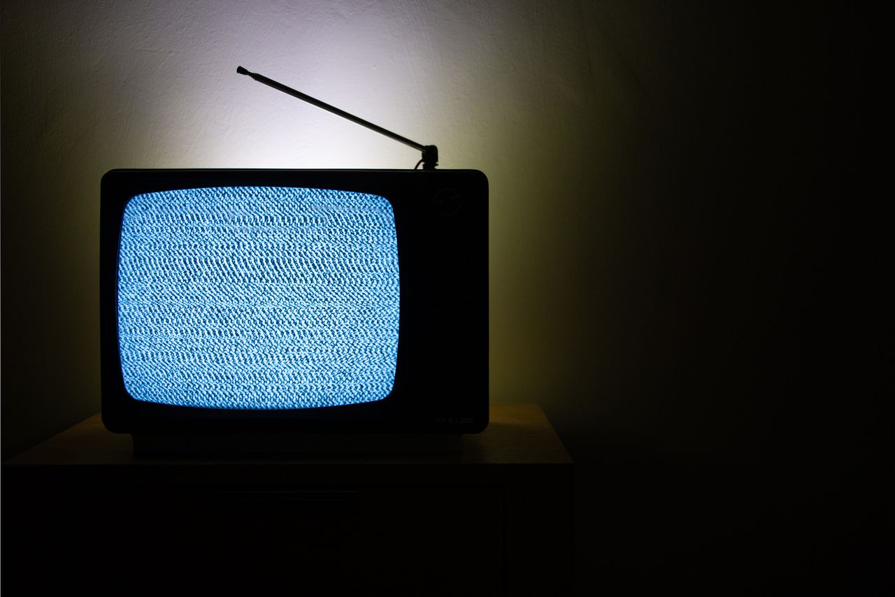 Old vintage television isolated on dark background with no signal and grainy noise