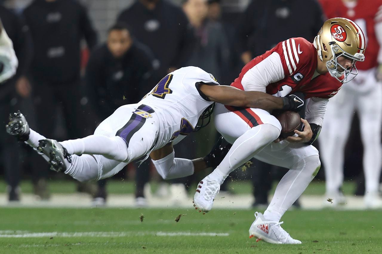 Baltimore Ravens cornerback Marlon Humphrey tackles San Francisco 49ers quarterback Brock Purdy