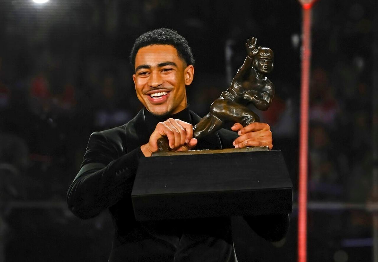 Alabama quarterback Bryce Young holds the Heisman Trophy