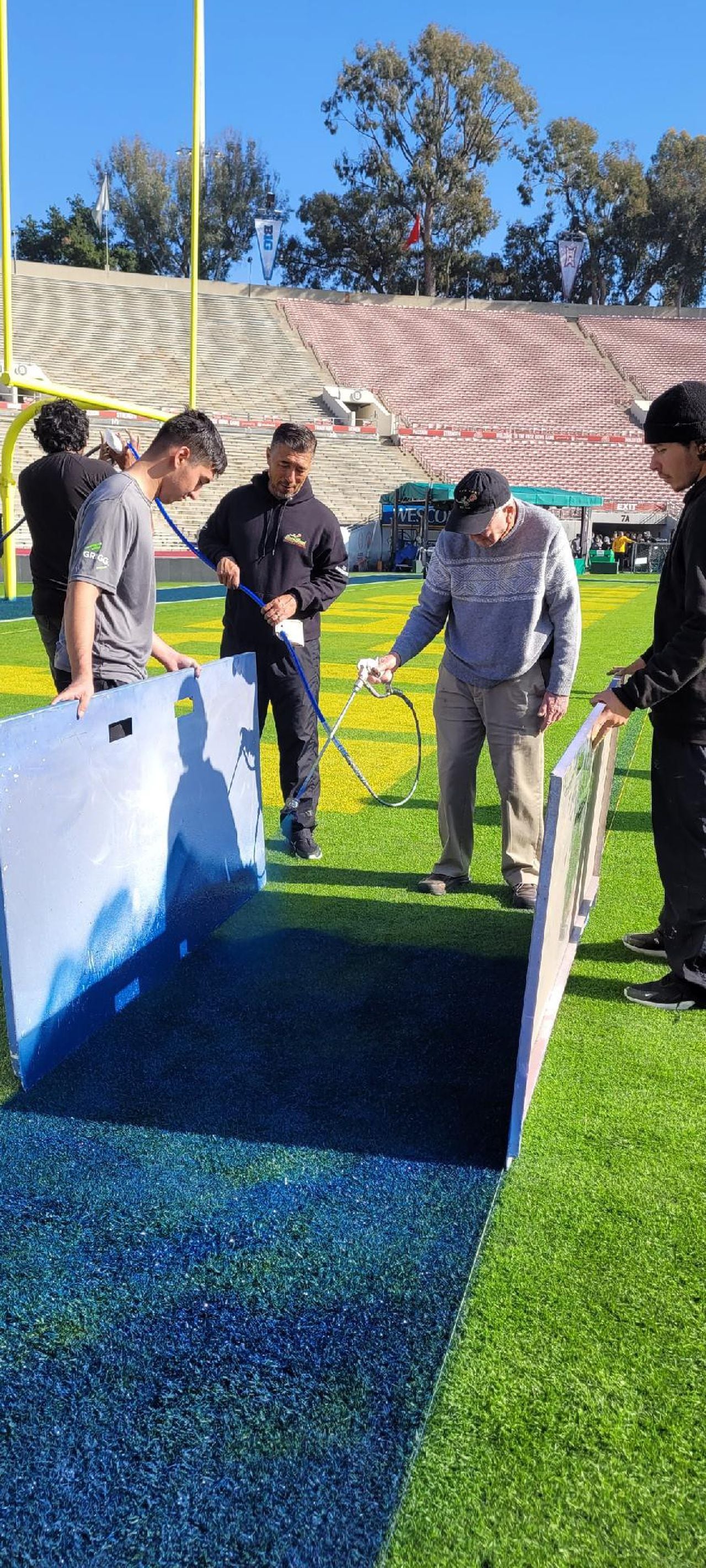 Reynolds Crutchfield helps paint Spieker Field at the Rose Bowl.