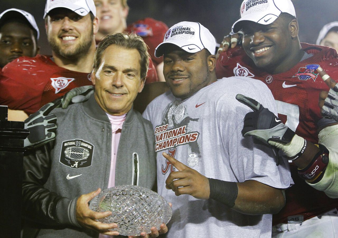 Alabama coach Nick Saban holds the BCS national-championship trophy while celebrating with running back Mark Ingram